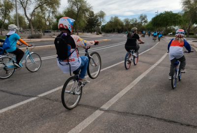 Four participants riding their bikes away from the camera