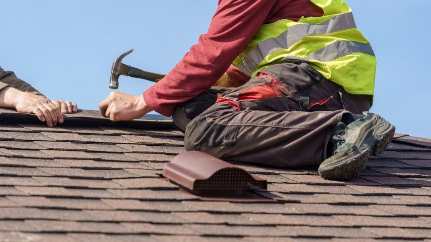 Man fixing a roof Man fixing a roof