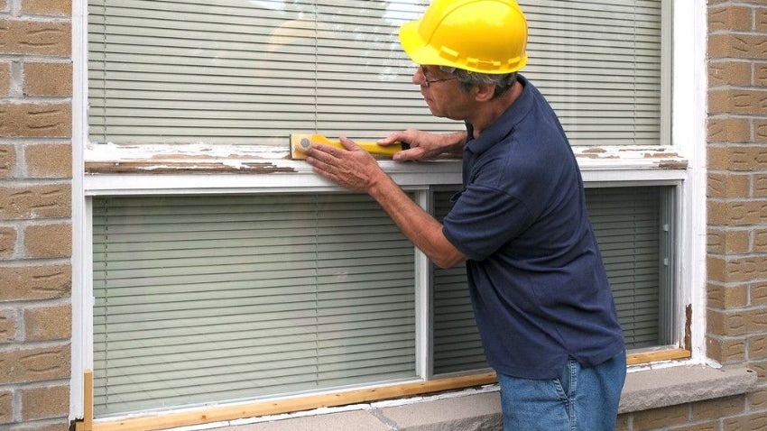 Construction worker fixing an exterior window Construction worker fixing an exterior window