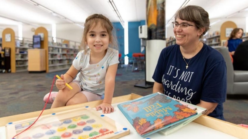Mom and daughter reading at the library