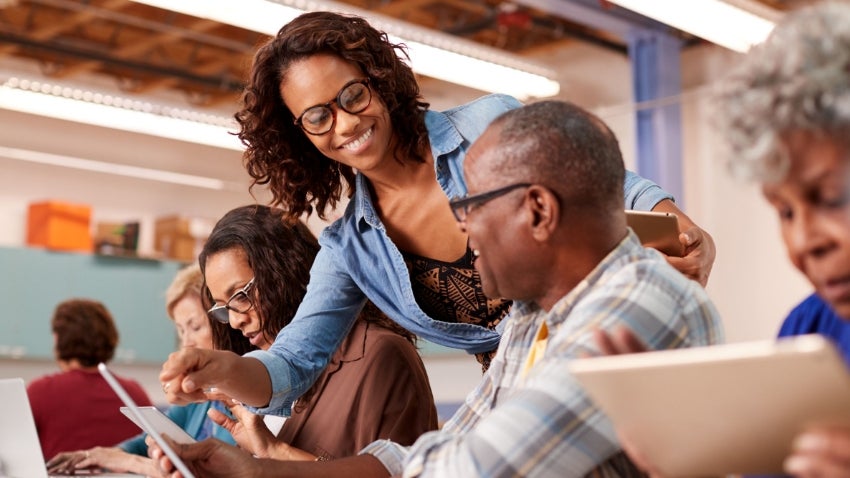 woman helping senior residents with technology
