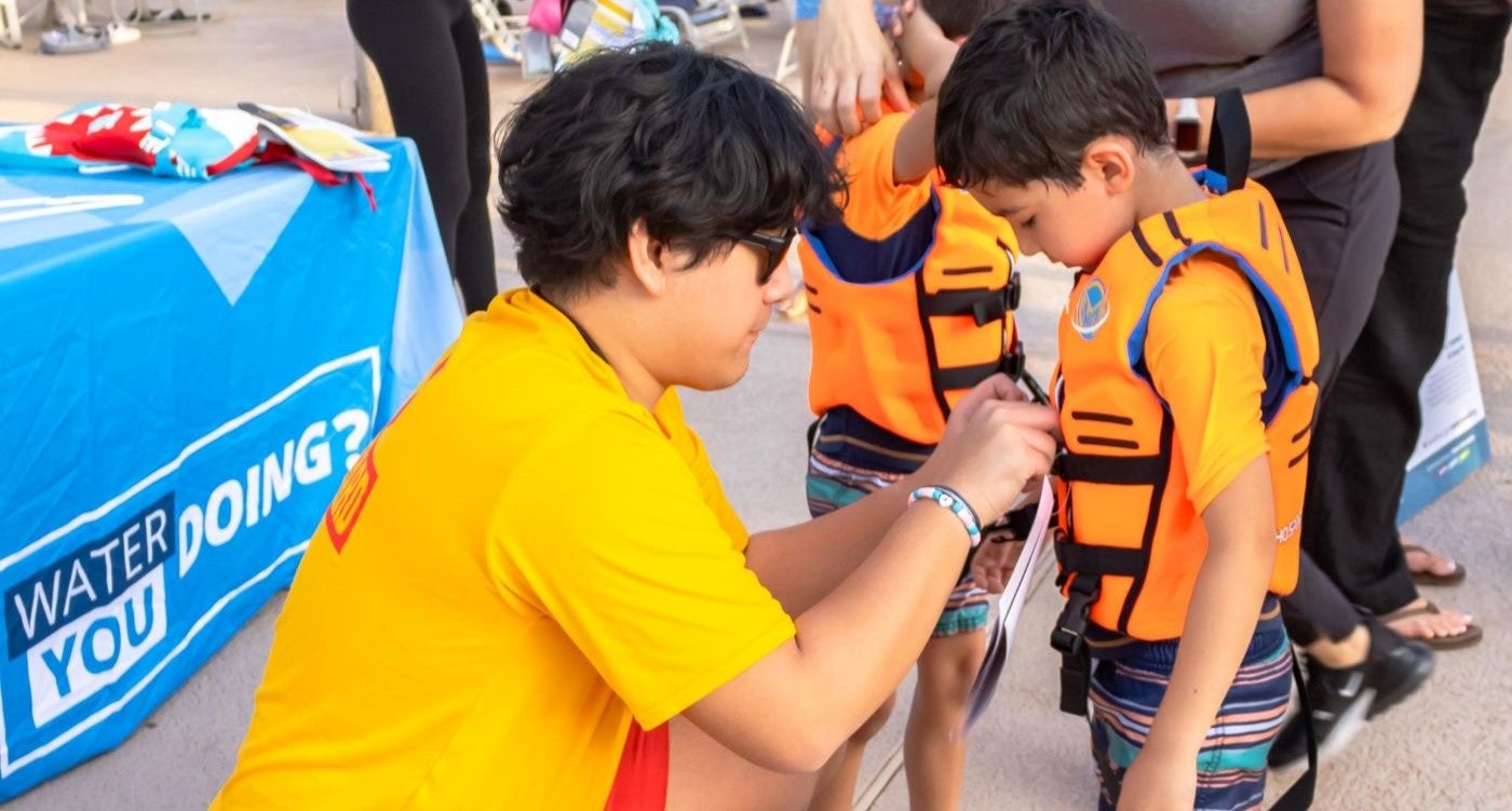 child getting fitted for a life jacket