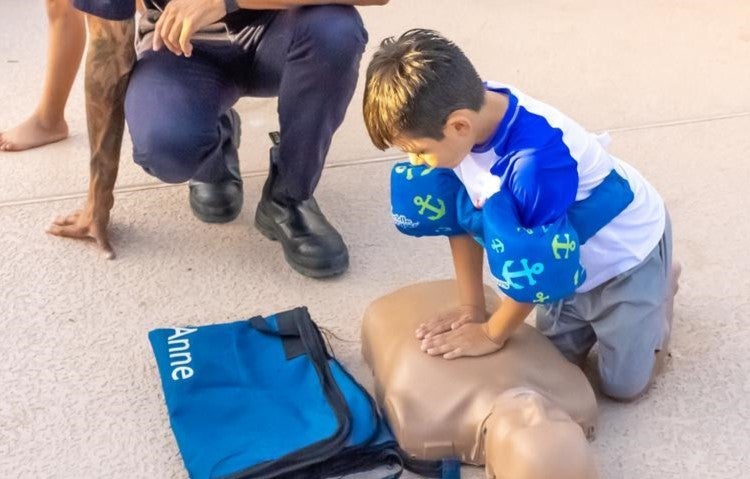 young boy doing cpr demo at water you doing event