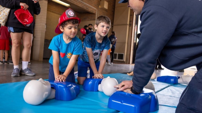 two young boys learning CPR at a CFD Open House