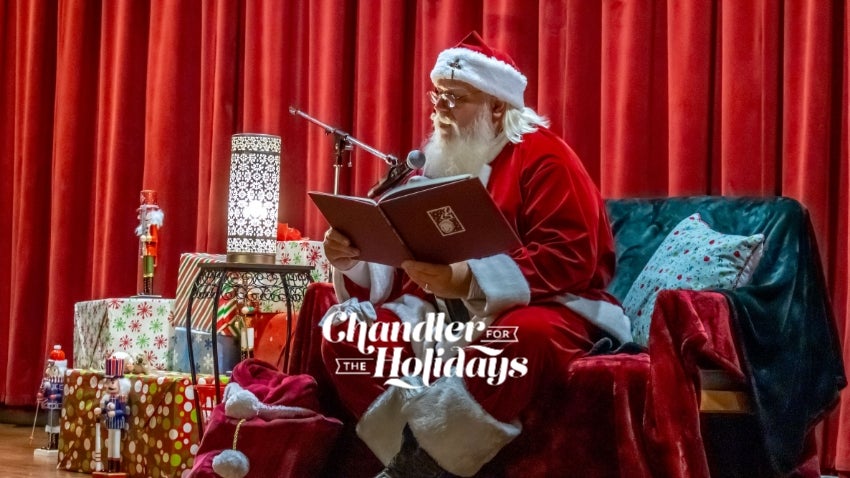 Santa surrounded by gifts on stage