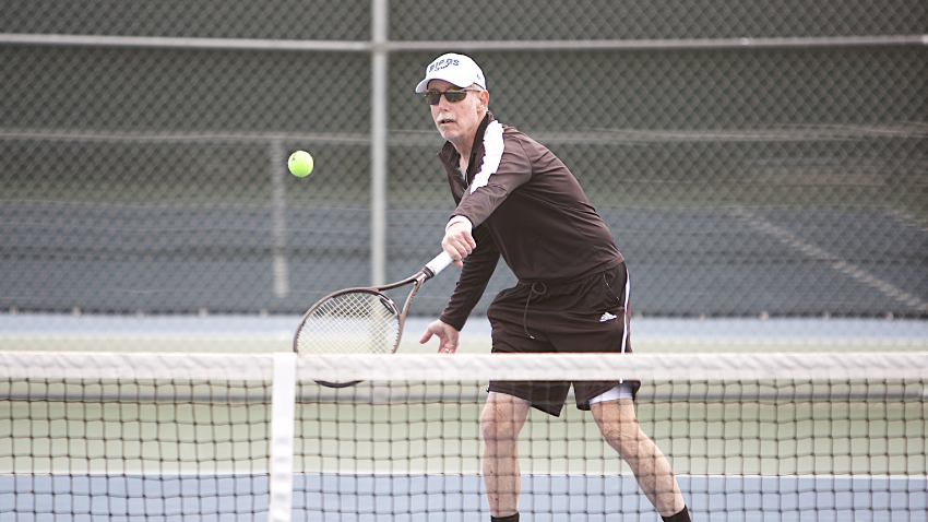 active adult hitting a tennis ball