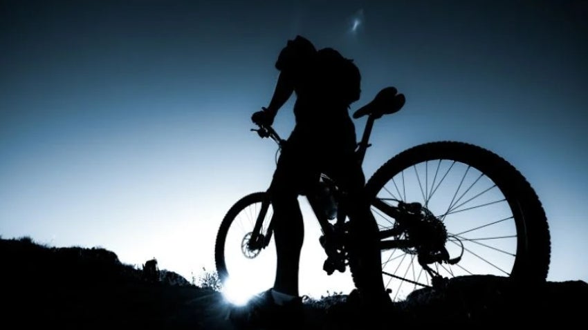 Silhouette of a mountain biker at night