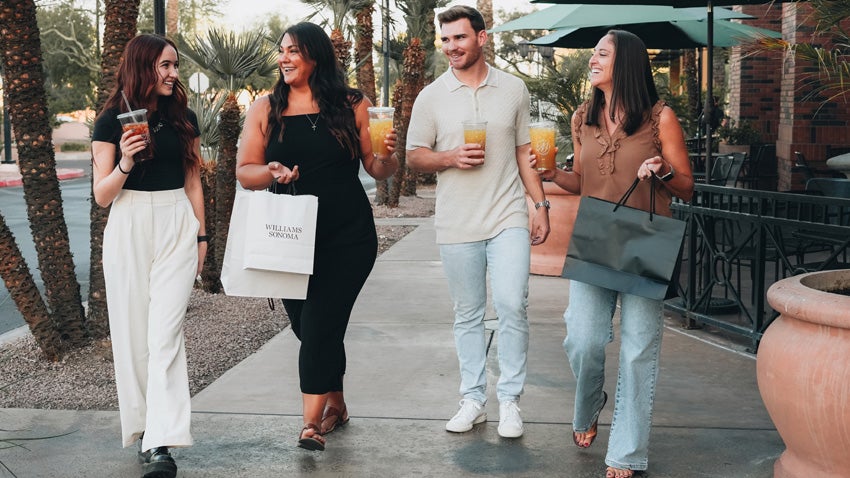 A group of young adults walking and talking while shopping at the Casa Paloma shopping center in Chandler