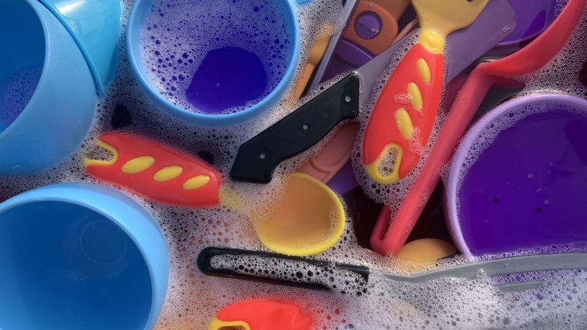 Toy plates and utensils in soapy water