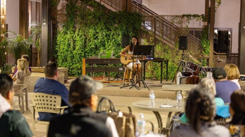 teen singing in courtyard of community center