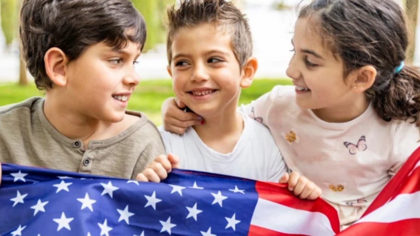 Two youths and a toddler holding the American flag