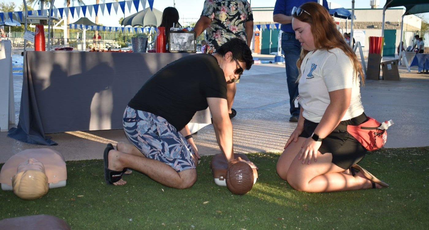 man learning CPR from city aquatics staff