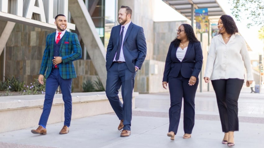 Four employees walking oustide of city hall