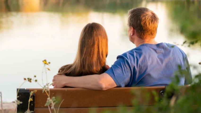 Couple sitting on a bench overlooking the lake at Veterans Oasis Park