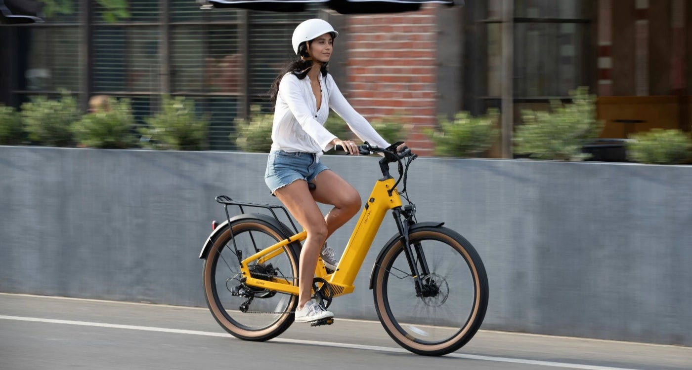 woman wearing a helment riding an e-bike