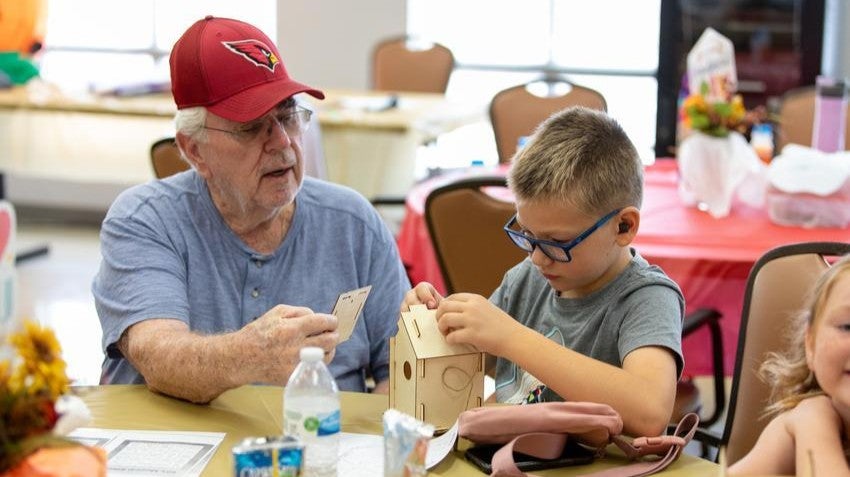 Grandparent and child doing a craft