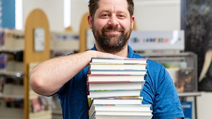 Man holding a stack of books