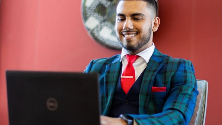 Man in suit sitting at table with laptop