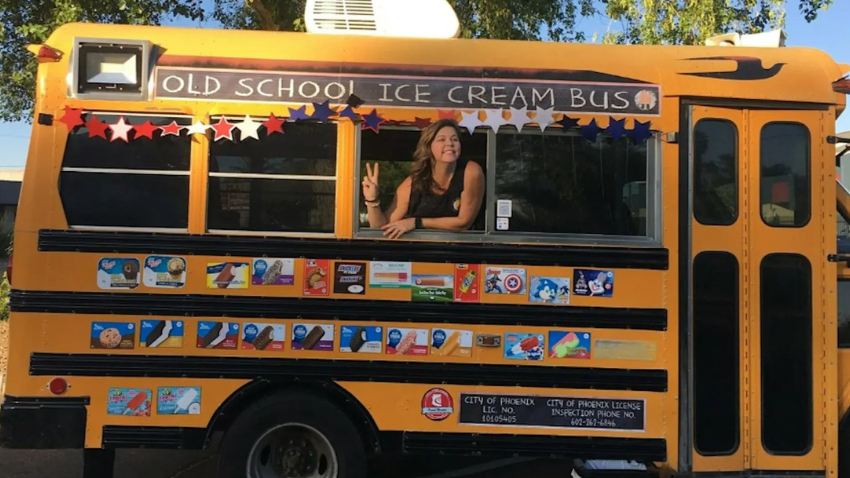 Women inside in yellow school bus with stickers of different ice creams on the bus
