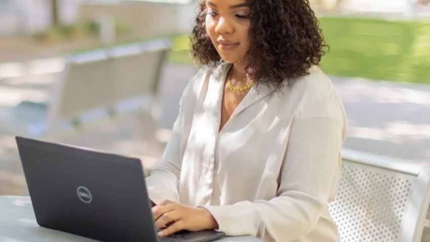Woman sitting outside with a laptop