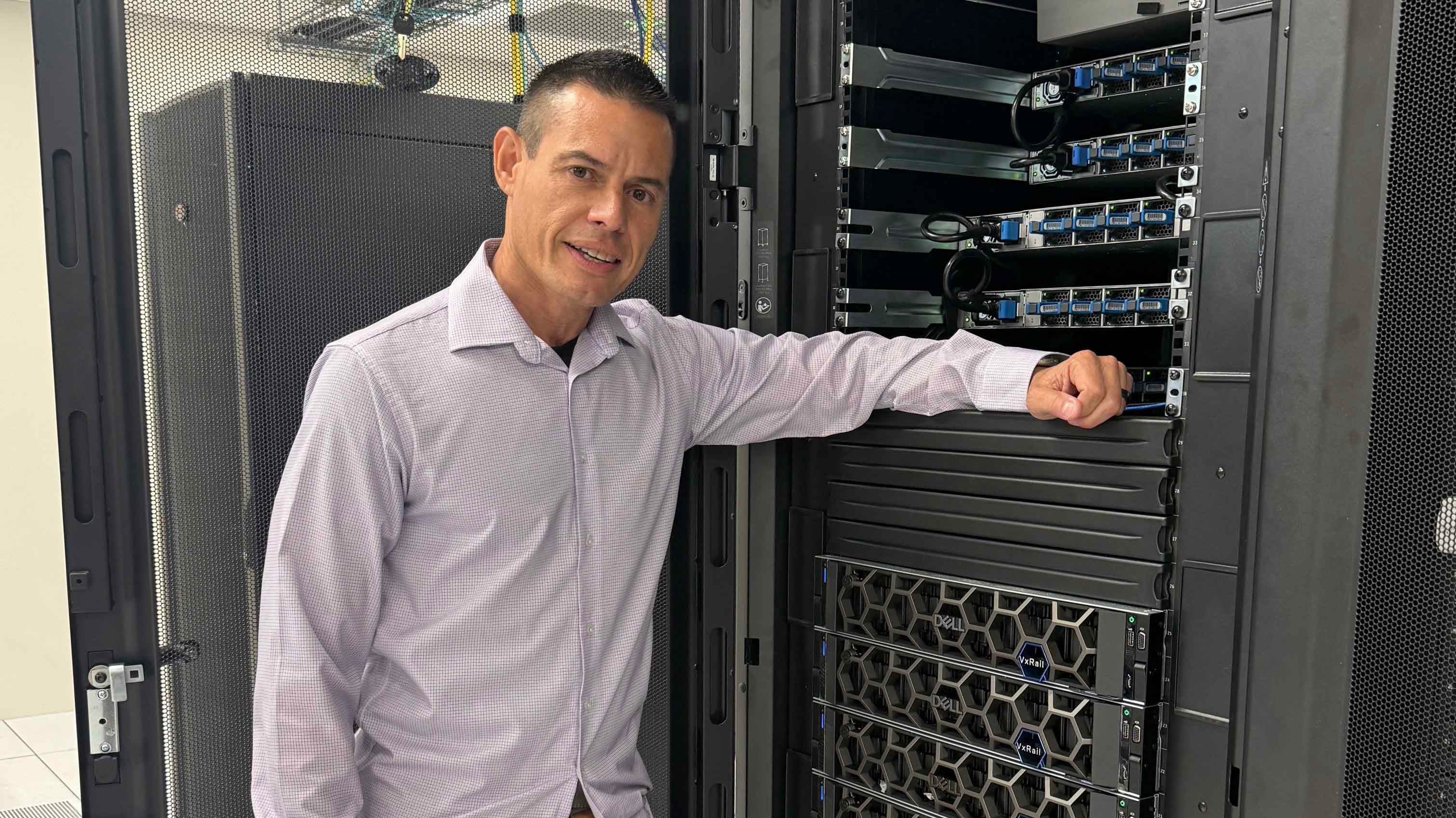 Caleb Torres, IT Infrastructure Manager for the City of Chandler leans against computer equipment
