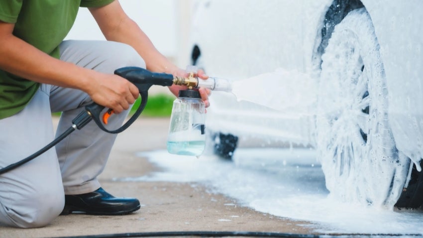 Man washing car in driveway