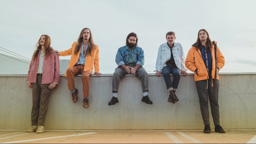 members of the Dean Nelson band siting on a fence