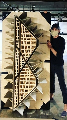 Artist Thomas Musca holding a model of the original X-Tendo bench design. 