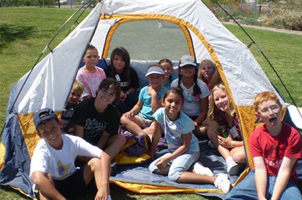 Youth camp participants sitting in a tent