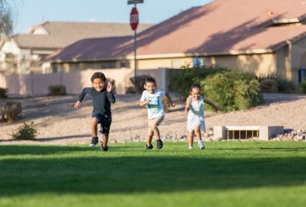 Kids running through a green belt