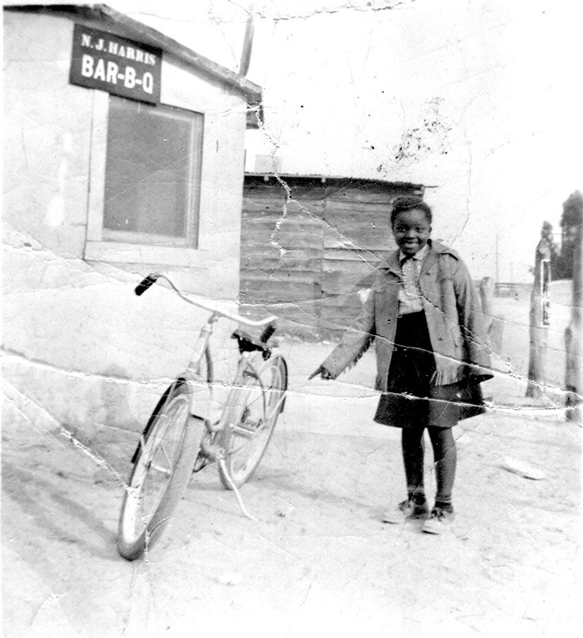 LaVon Harris standing in front of N.J. Harris' BBQ restaurant, 1930s. Chandler Museum Collection, 2001.32.3