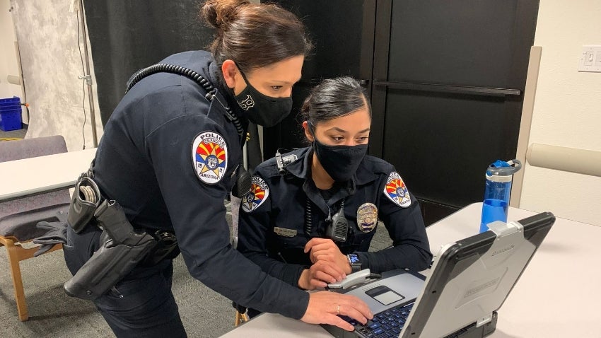Two police officers reviewing a case