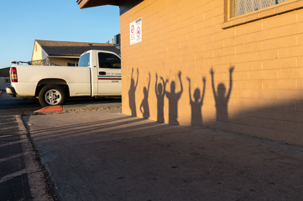 Shadows of young kids on the side of a public housing site