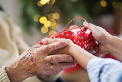 Close-up of hands of senior and young woman holding a present at Christmas
