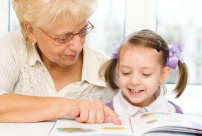 Senior female reading to a young girl