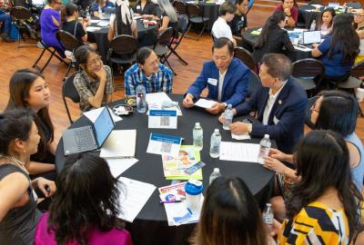 Group of Asian Americans sitting at a round table conversing