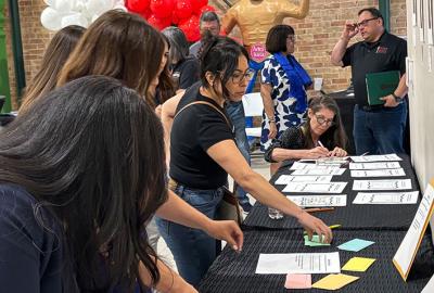 Women grabbing pieces of paper off a table