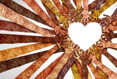 Hands made out of paper in shades of brown meet in the middle to form a heart