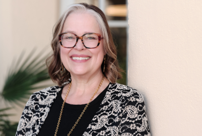 Michelle Mac Lennan standing in front of a tan wall