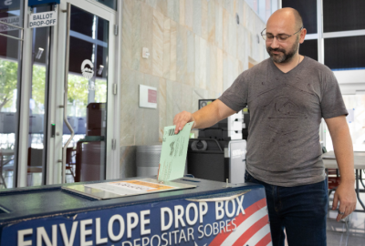 Man dropping voted ballot at Chandler City Hall in drop off box