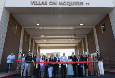 City of Chandler executives and partners in front of a red ribbon at Villas on McQueen