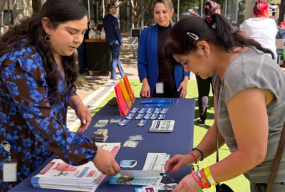 Female Golden Neighbor reviews brochures from a city department at an informational booth