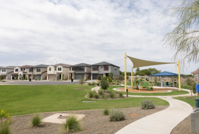 Neighborhood playground on a greenbelt with single-family homes in the background