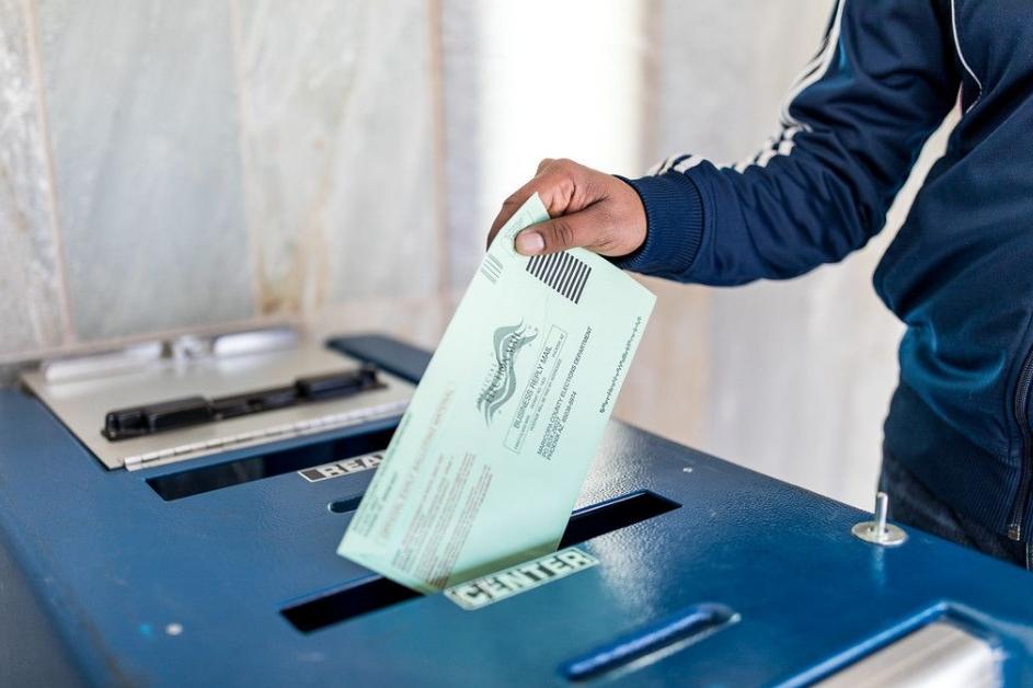 Voter putting ballot in secured ballot box