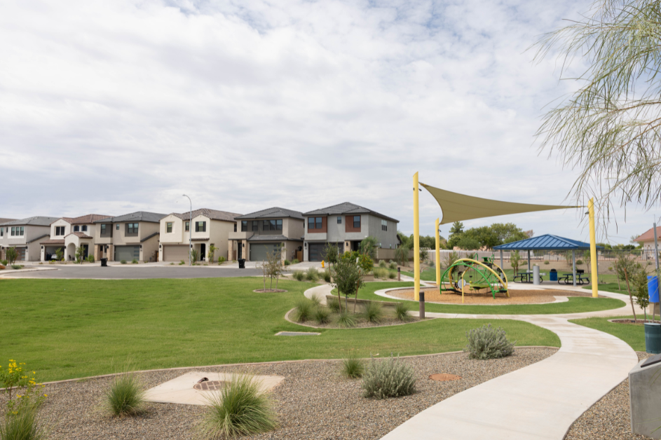 Neighborhood playground on a greenbelt with single-family homes in the background