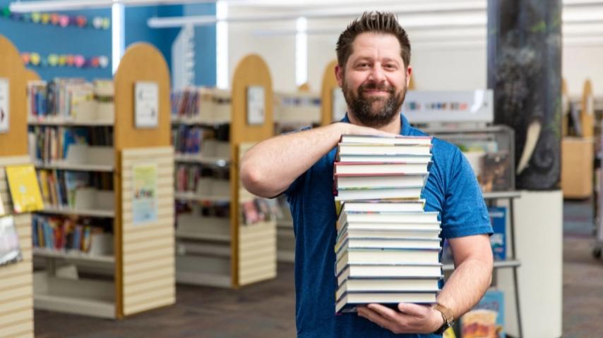man holding a stack of books