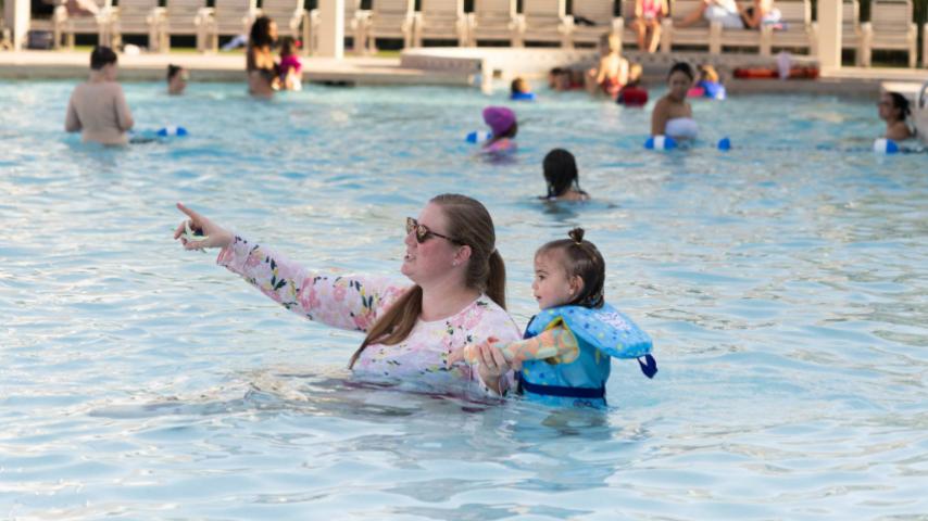 mother and daughter in the pool holding hands
