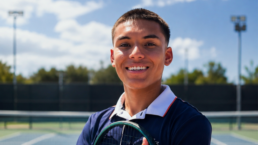 Lee the tennis pro, smiling holding a tennis racket