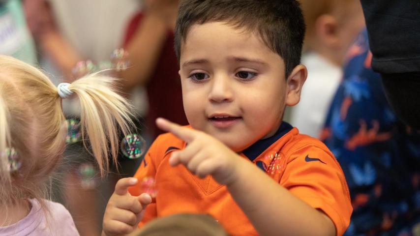 young child playing with bubbles