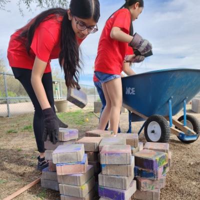 teens working outside moving bricks